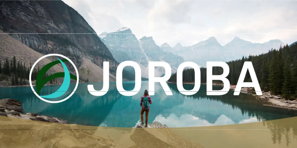 Eine Wanderin auf einem Felsen mit einem inspirierendem Ausblick. Darüber der Name JOROBA.